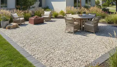 Professional pea gravel patio installation with edging and furniture in Olathe, KS landscaping project